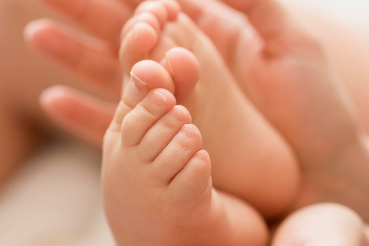 close-up-mom-holding-baby-s-feet-hands-2